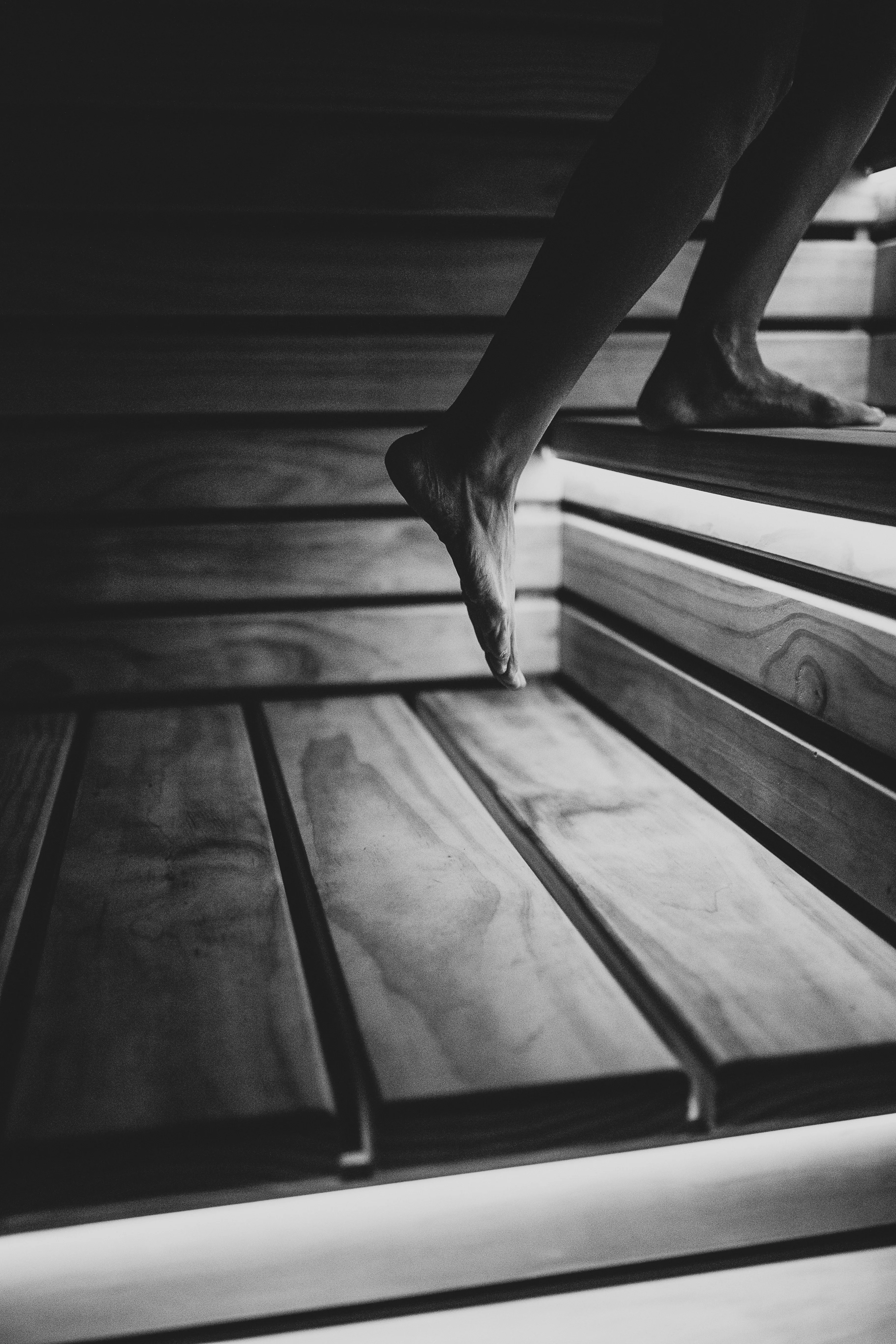 The upstairs rest lounge at Blue Mountains Sauna, with the Sit, Sweat, Chill, Repeat ethos on the timber wall and a wood fire glowing alongside the long bench.