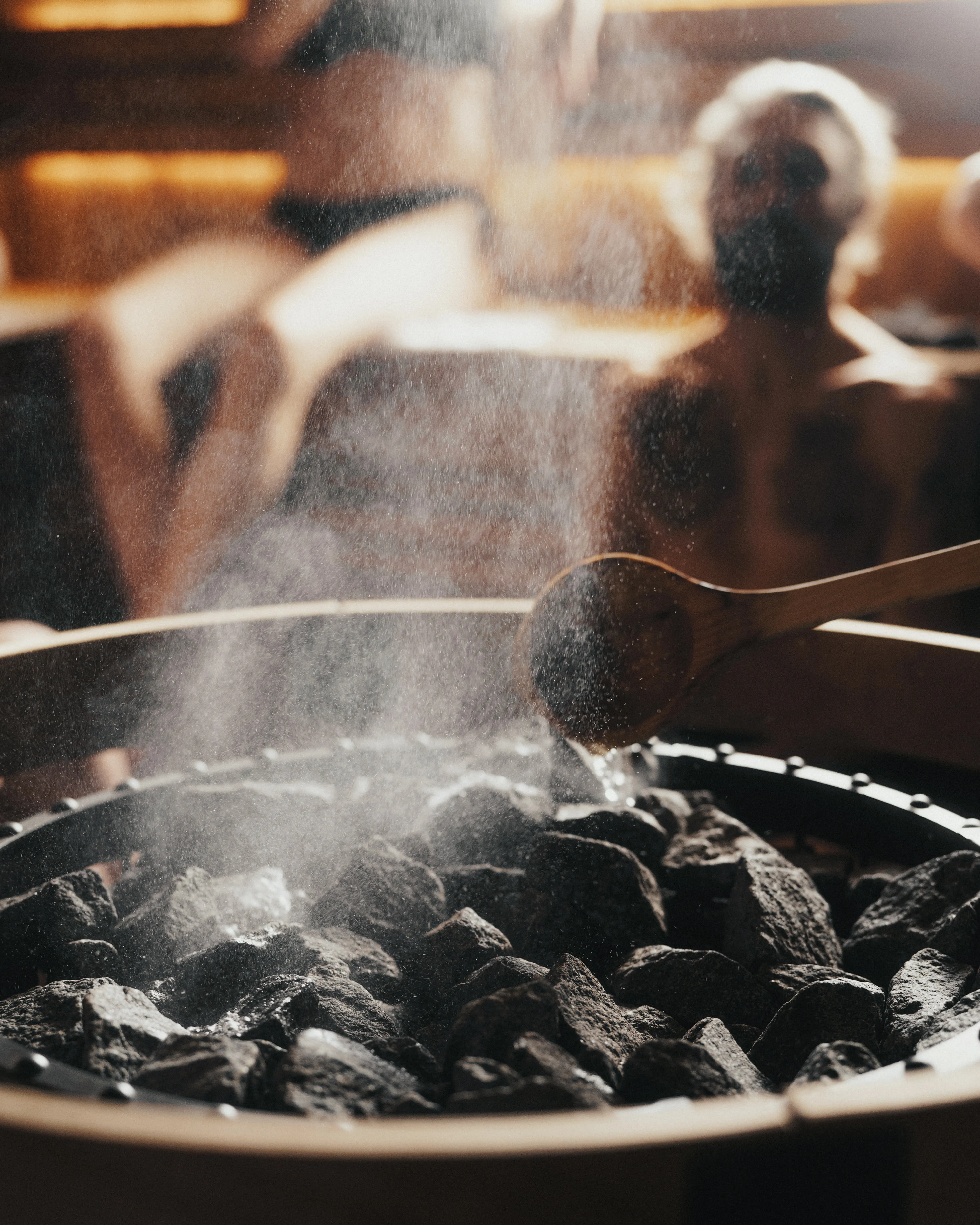 Steam rises as water is ladled onto the glowing stove at Blue Mountains Sauna.