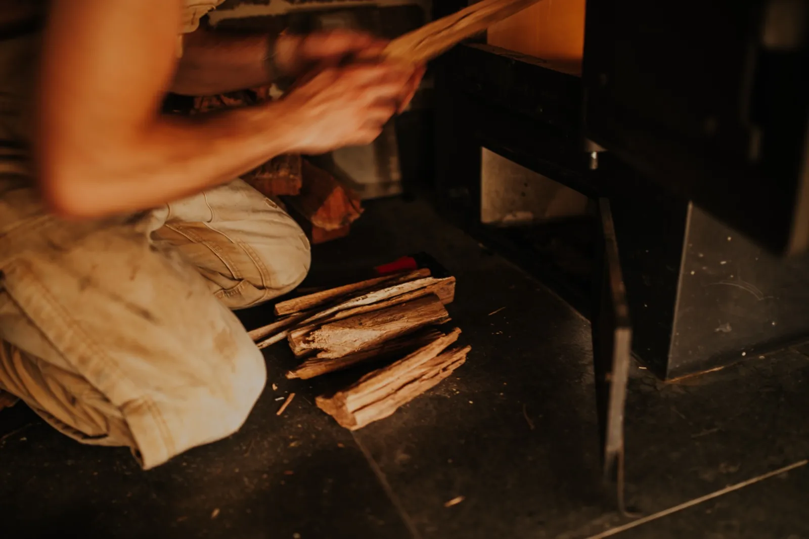 Loading split wood into the wood-fired savusauna stove