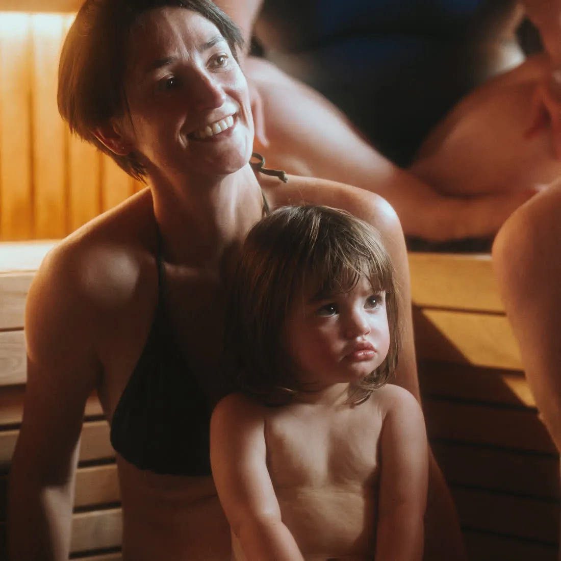 A mum and her toddler together in the sauna