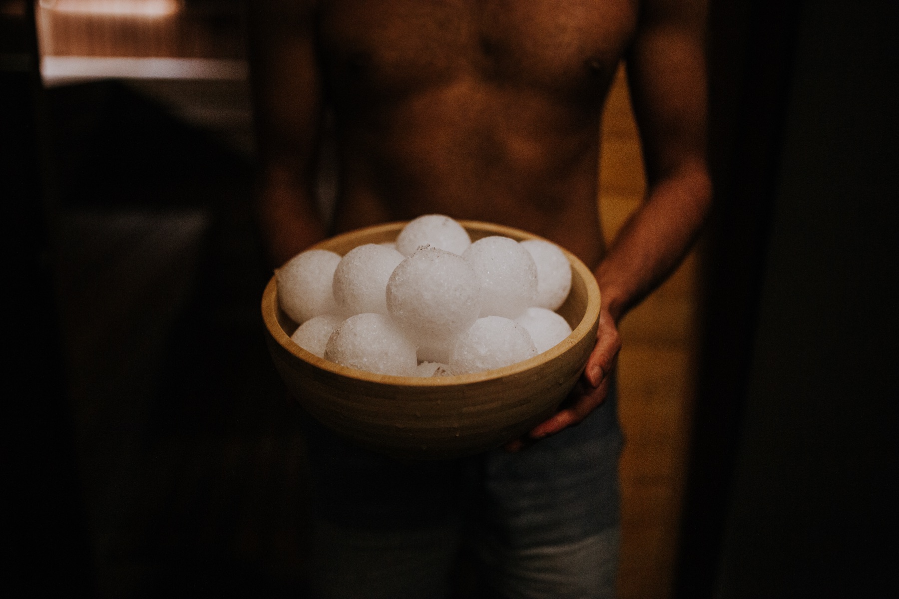 Saunameister holding a wooden bowl of ice