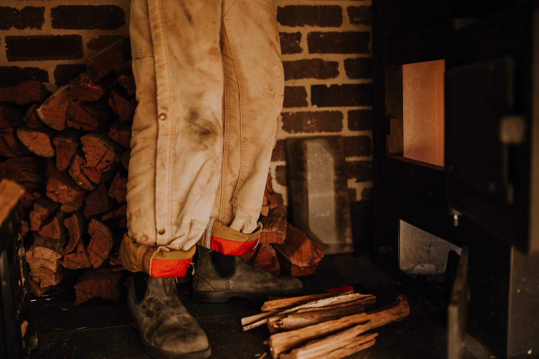 Stacking firewood beside the wood-fired stove